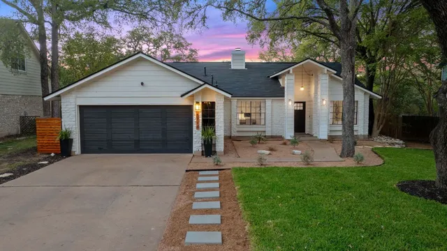 a view of a house with backyard and a tree