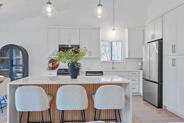a living room with furniture kitchen view and a chandelier