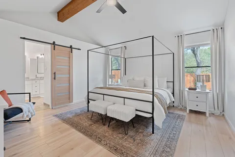 a kitchen with stainless steel appliances granite countertop a dining table chairs refrigerator and sink