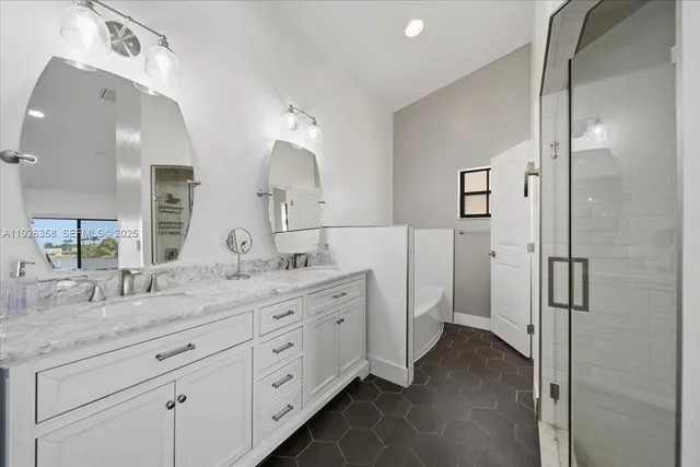 a spacious bathroom with a granite countertop sink mirror and shower
