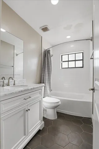 a bathroom with a double vanity sink toilet and shower