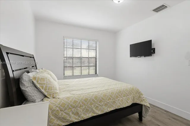 a bedroom with a bed and a flat screen tv