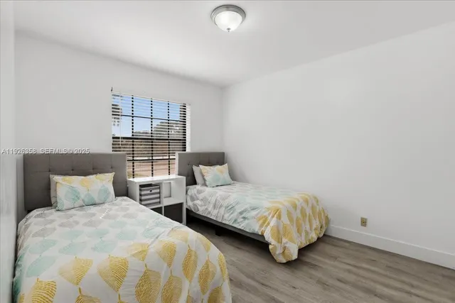 a bedroom with two beds and a window