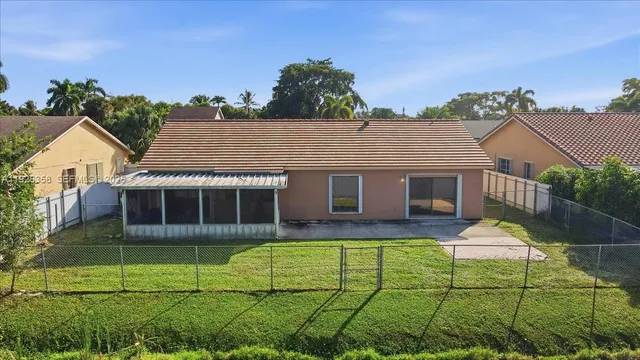 a front view of a house with a yard and potted plants