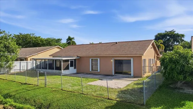 a view of house with backyard and swimming pool