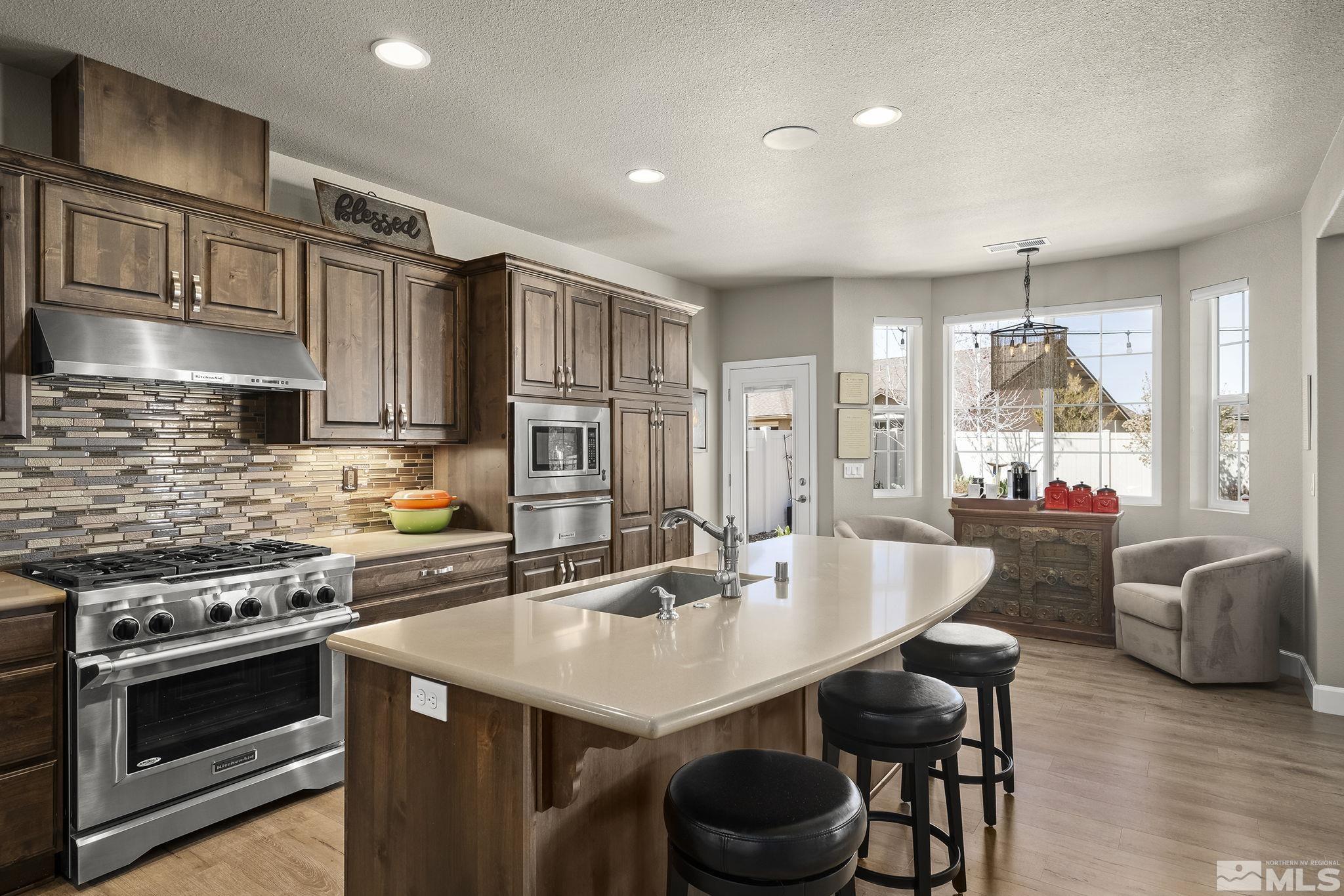 2173 Berkich Court Reno, NV 89521 - Photo 7 of 29 a kitchen with stainless steel appliances a table chairs and a refrigerator