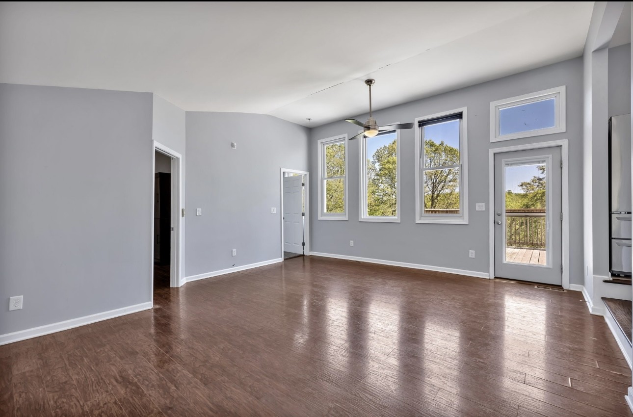 1104 Deer Ridge Road Kingston Springs, TN 37082 - Photo 5 of 36 an empty room with wooden floor and windows