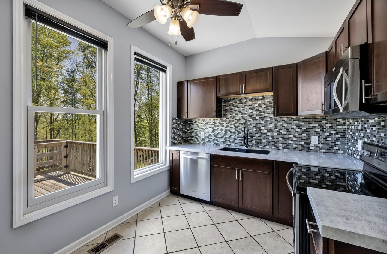 1104 Deer Ridge Road Kingston Springs, TN 37082 - Photo 7 of 36 a kitchen with stainless steel appliances a sink stove and cabinets