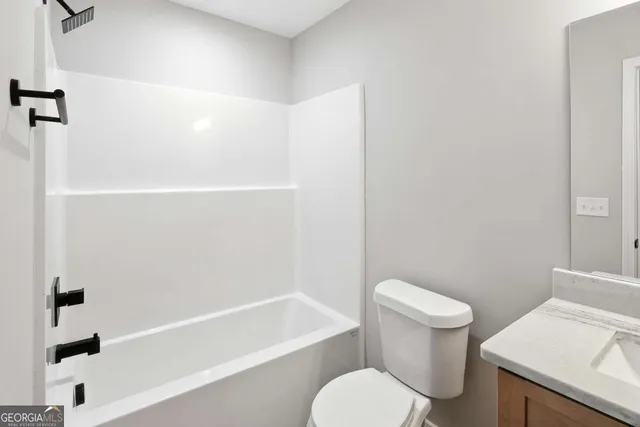 a white toilet and tub sitting next to a bathroom sink