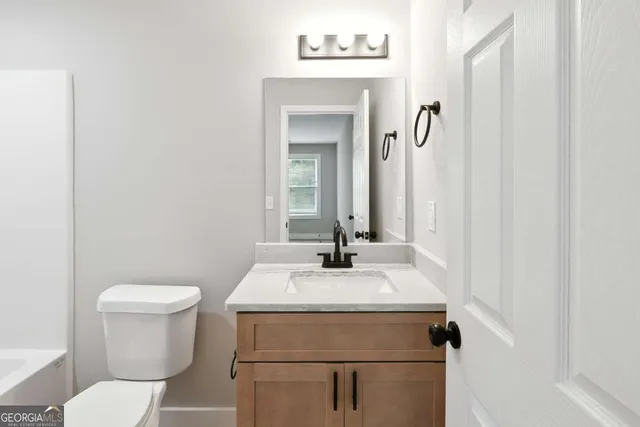 a bathroom with a sink toilet and mirror