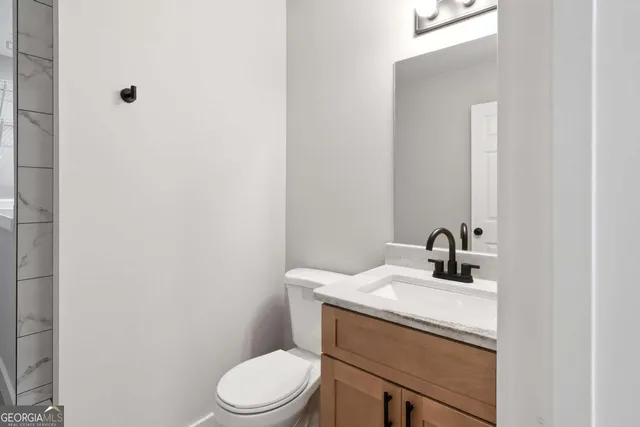 a bathroom with a toilet sink and mirror