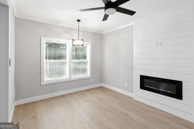 a view of wooden floor cabinets and a ceiling fan in a room