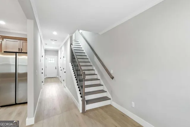 a view of a hallway with staircase and white walls