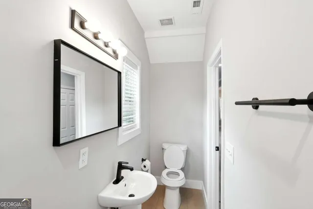 a bathroom with a toilet sink and mirror