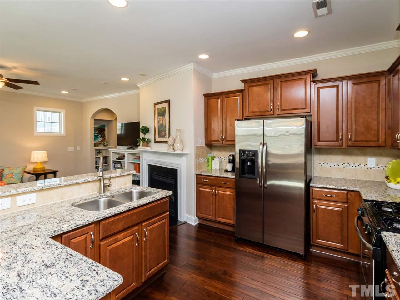 1589 Fullerton Place Raleigh, NC 27607 - Photo 11 of 25 a kitchen with stainless steel appliances granite countertop a refrigerator a sink dishwasher a stove with wooden cabinets and wooden floor