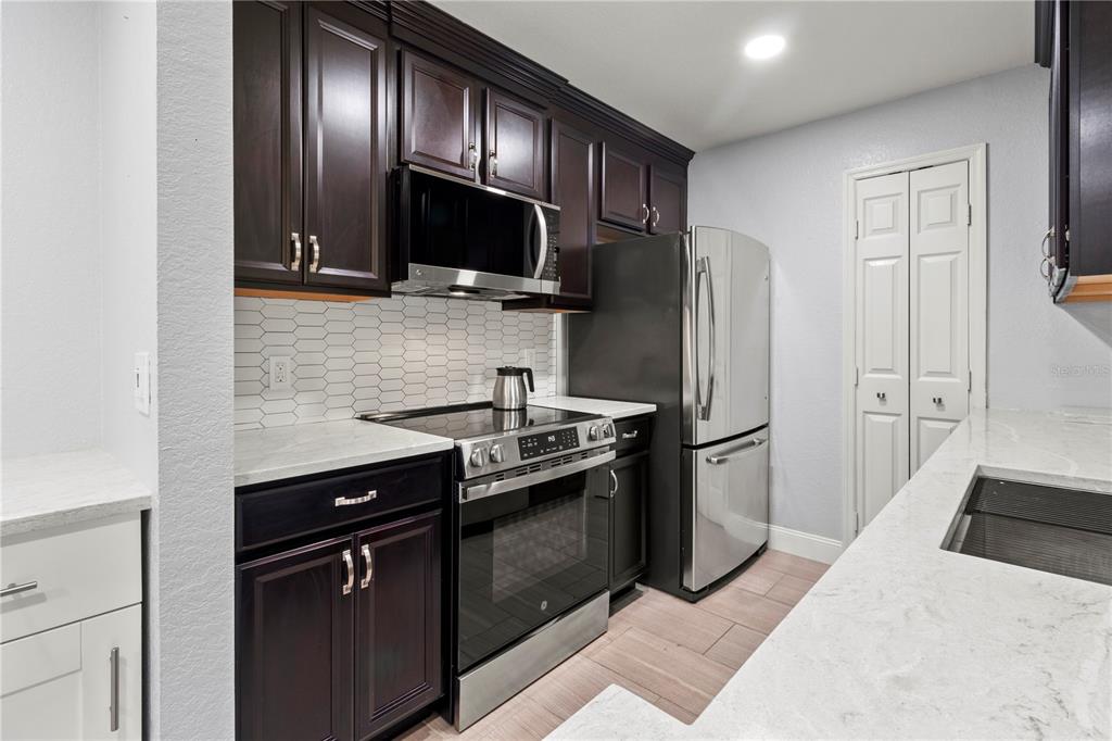 8911 Manor Loop, Unit 204 Lakewood Ranch, FL 34202 - Photo 13 of 45 a kitchen with granite countertop stainless steel appliances and wooden cabinets