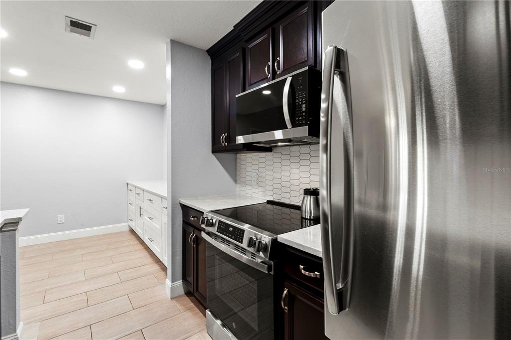 8911 Manor Loop, Unit 204 Lakewood Ranch, FL 34202 - Photo 15 of 45 a kitchen with stainless steel appliances granite countertop a refrigerator and a stove