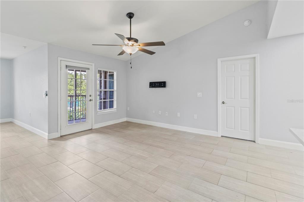 8911 Manor Loop, Unit 204 Lakewood Ranch, FL 34202 - Photo 17 of 45 an empty room with chandelier fan and windows