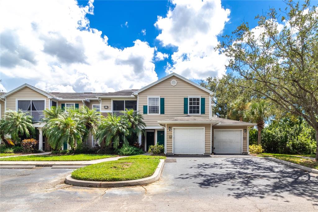 8911 Manor Loop, Unit 204 Lakewood Ranch, FL 34202 - Photo 2 of 45 a front view of a house with a yard and trees