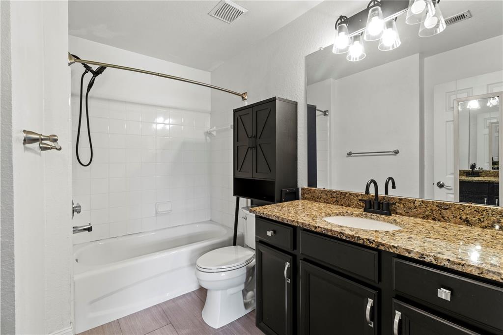 8911 Manor Loop, Unit 204 Lakewood Ranch, FL 34202 - Photo 26 of 45 a bathroom with a granite countertop sink a toilet and shower
