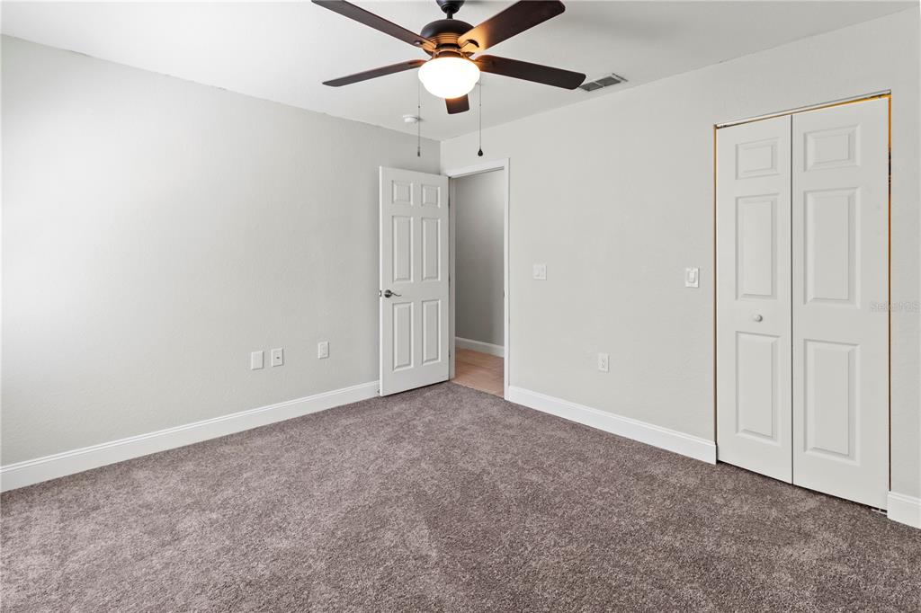 8911 Manor Loop, Unit 204 Lakewood Ranch, FL 34202 - Photo 27 of 45 an empty room with closet and a chandelier fan