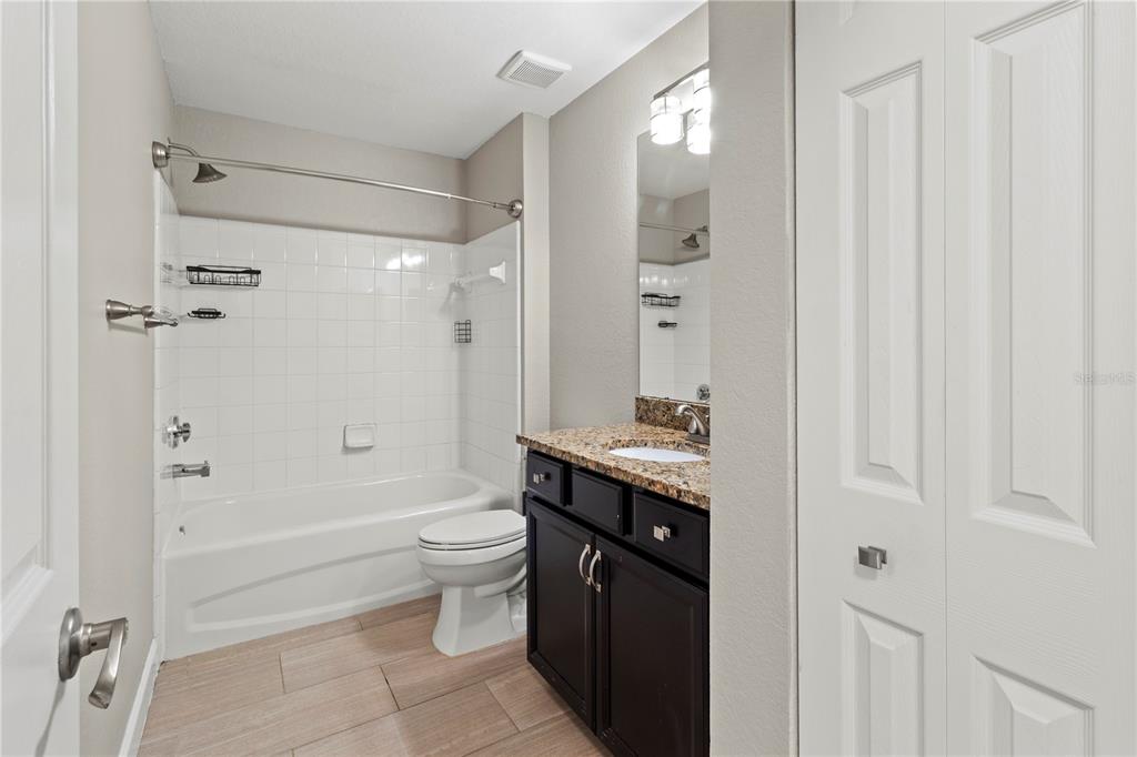 8911 Manor Loop, Unit 204 Lakewood Ranch, FL 34202 - Photo 28 of 45 a bathroom with a granite countertop sink toilet and shower