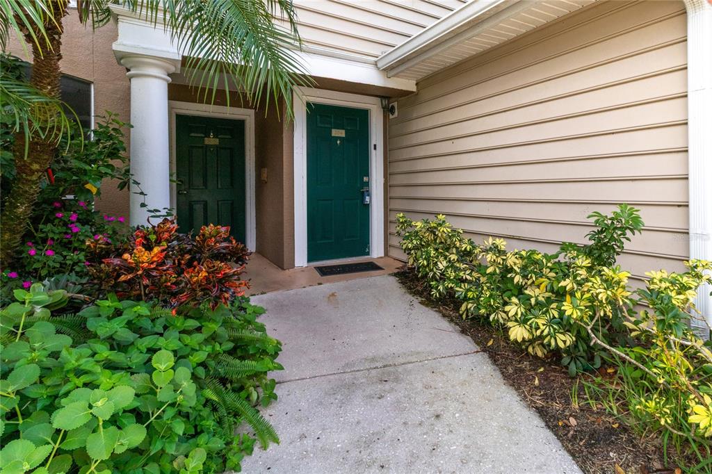 8911 Manor Loop, Unit 204 Lakewood Ranch, FL 34202 - Photo 8 of 45 a view of a pathway that has potted plants