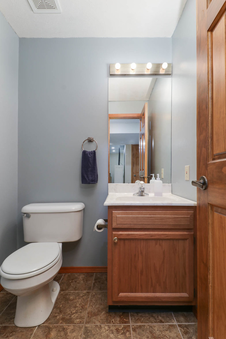 3203 Eagle Crest Road Bloomington, IL 61704 - Photo 36 of 52 a bathroom with a toilet a sink and mirror
