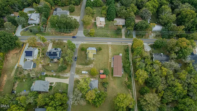 an aerial view of residential house with outdoor space and trees all around