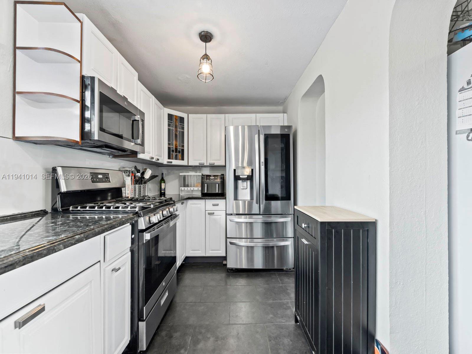 12301 Southwest 28th Street Miami, FL 33175 - Photo 13 of 46 a kitchen with stainless steel appliances granite countertop a refrigerator a stove top oven a sink and dishwasher