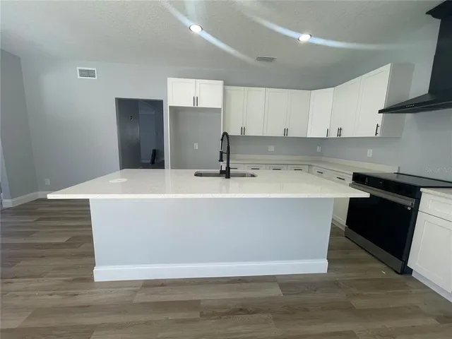 a kitchen with a sink and wooden floor