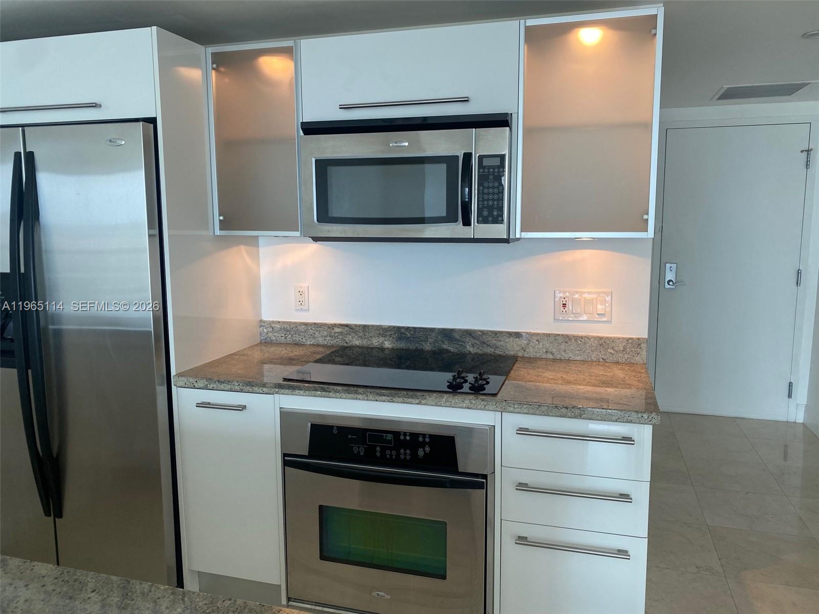 185 Southwest 7th Street, Unit 1705 Miami, FL 33130 - Photo 3 of 7 a kitchen with a stove and a microwave