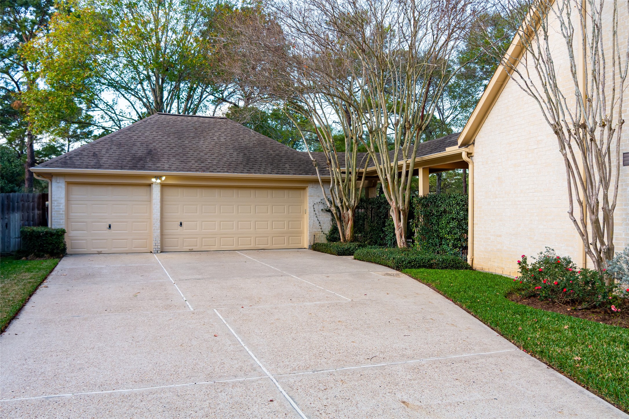 22806 2 Rivers Lane Katy, TX 77450 - Photo 12 of 49 Spacious three-car garage with an extended private driveway offering ample room for additional vehicles and guest parking. The backyard is enhanced by mature landscaping along the fence line, providing excellent privacy and a secluded outdoor setting.