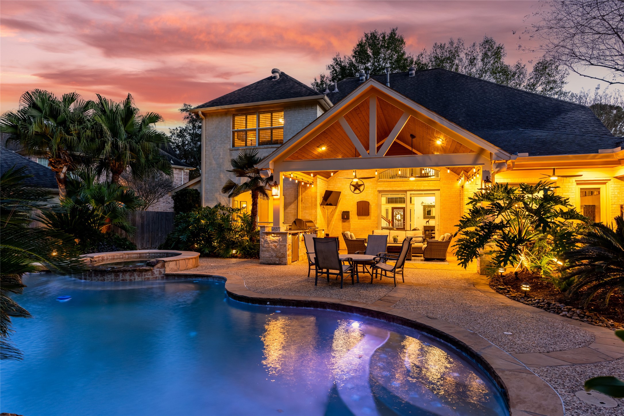 22806 2 Rivers Lane Katy, TX 77450 - Photo 2 of 49 Resort style living designed for unforgettable family moments! Imagine spending your time relaxing in your stunning backyard oasis featuring a sparkling pool with adjacent spa, surrounded by lush landscaping. The spacious patio has the perfect lighting under a charming, covered patio area.