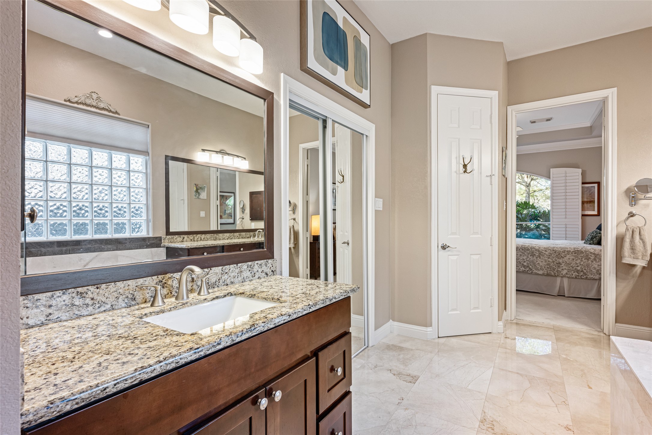 22806 2 Rivers Lane Katy, TX 77450 - Photo 31 of 49 This welcoming primary bathroom offers granite countertops, a sleek vanity, and ample lighting. It features a large mirror, travertine flooring, and neutral tones. Two closets are located in this serene primary bathroom.