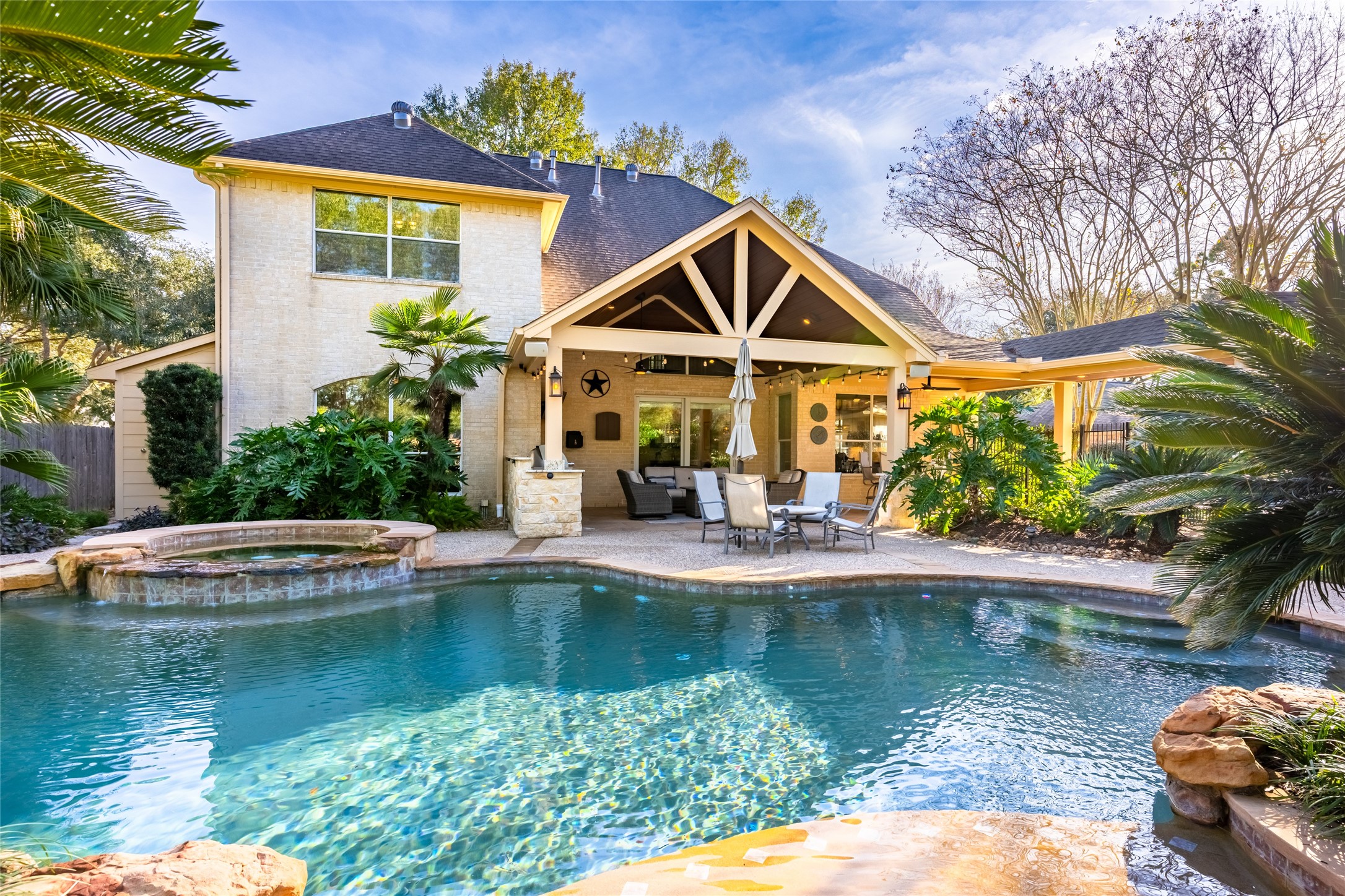 22806 2 Rivers Lane Katy, TX 77450 - Photo 42 of 49 This inviting home features a spacious backyard with a beautifully designed pool and waterfall, surrounded by lush landscaping. The covered patio area is perfect for outdoor dining and entertaining.
