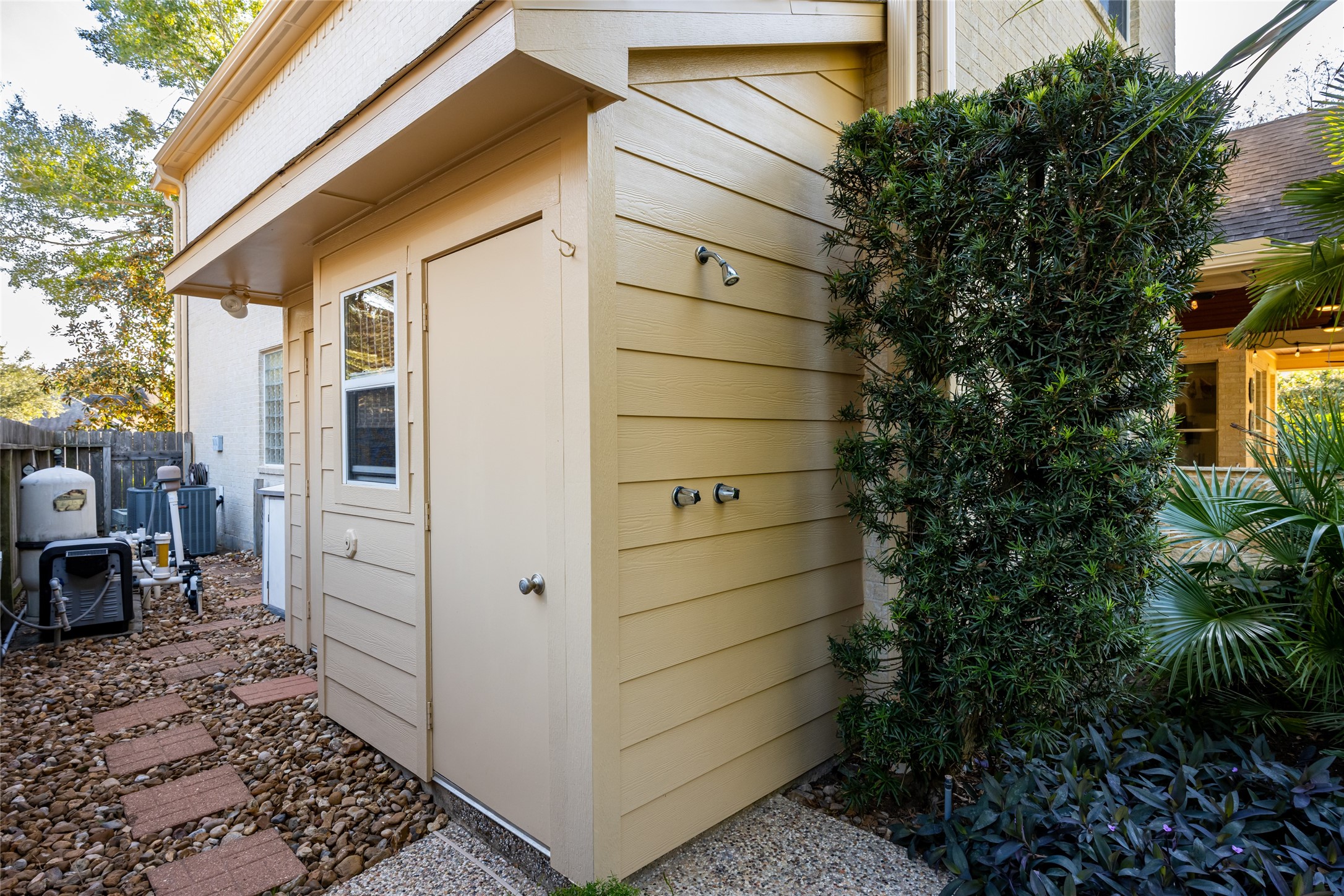 22806 2 Rivers Lane Katy, TX 77450 - Photo 44 of 49 Convenient outdoor bathroom featuring a heated shower-perfect for pool days, gardening, or outdoor entertaining. This private, well-designed space allows guests to rinse off and refresh without tracking water through the home, adding both comfort and functionality to the backyard oasis.