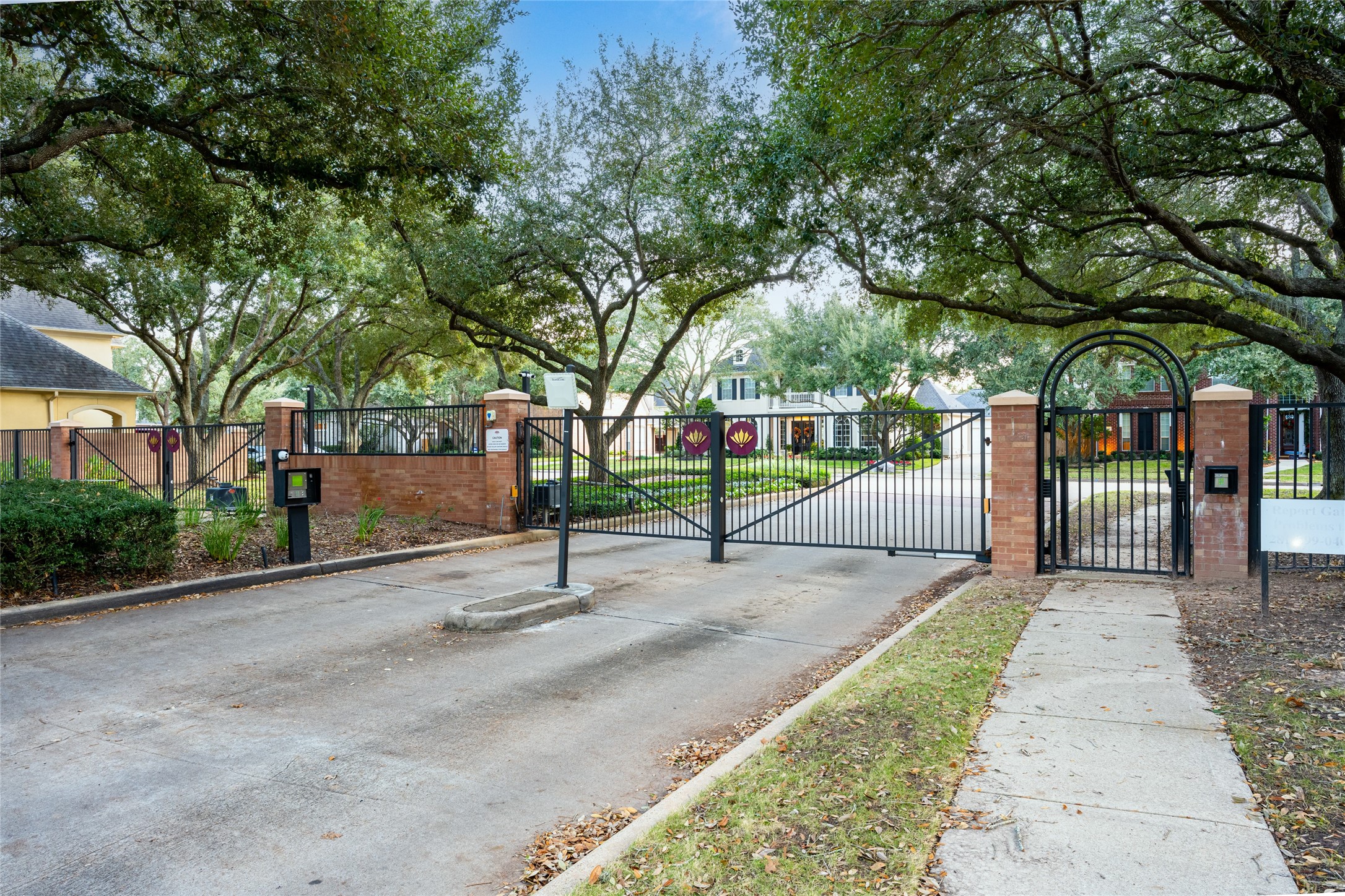 22806 2 Rivers Lane Katy, TX 77450 - Photo 47 of 49 Gated entrance to the residential neighborhood community of Fairway Manor, featuring a secure, iron gate with brick pillars. The area is surrounded by mature trees and well-maintained landscaping, providing a welcoming and private entrance.