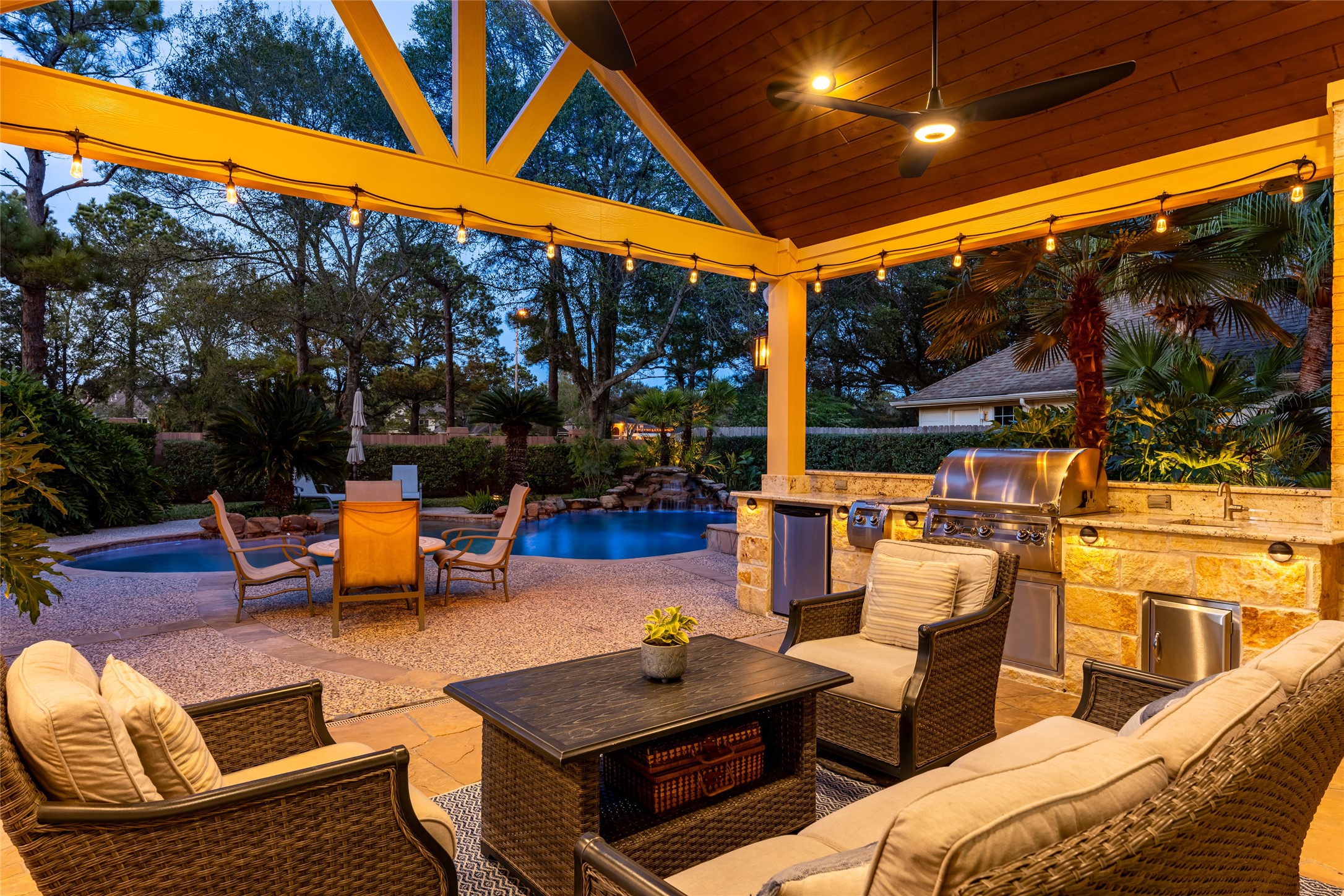 22806 2 Rivers Lane Katy, TX 77450 - Photo 5 of 49 This outdoor space features a covered patio, a built-in grill, and ceiling fan. It overlooks the pool with surrounding lush landscaping, creating a perfect setting for entertaining or relaxing. Set on a coveted lot with no rear neighbors. Beyond the brick fence (maintained by the HOA) the home enjoys peaceful views of the golf course and an open, airy backdrop that enhances both privacy and natural light. The fan provides amazing circulation.