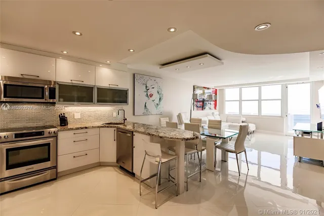 a kitchen with stainless steel appliances kitchen island granite countertop a table and chairs in it