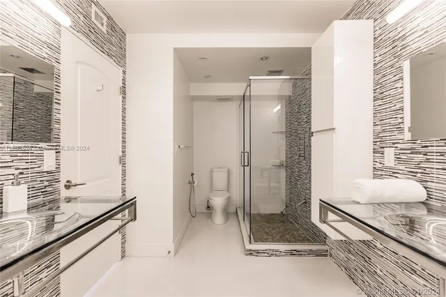 a bathroom with a granite countertop sink a toilet and shower