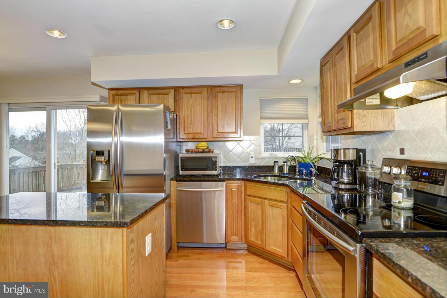 9522 Rommel Drive Columbia, MD 21046 - Photo 3 of 30 a kitchen with stainless steel appliances granite countertop a sink a stove and a refrigerator