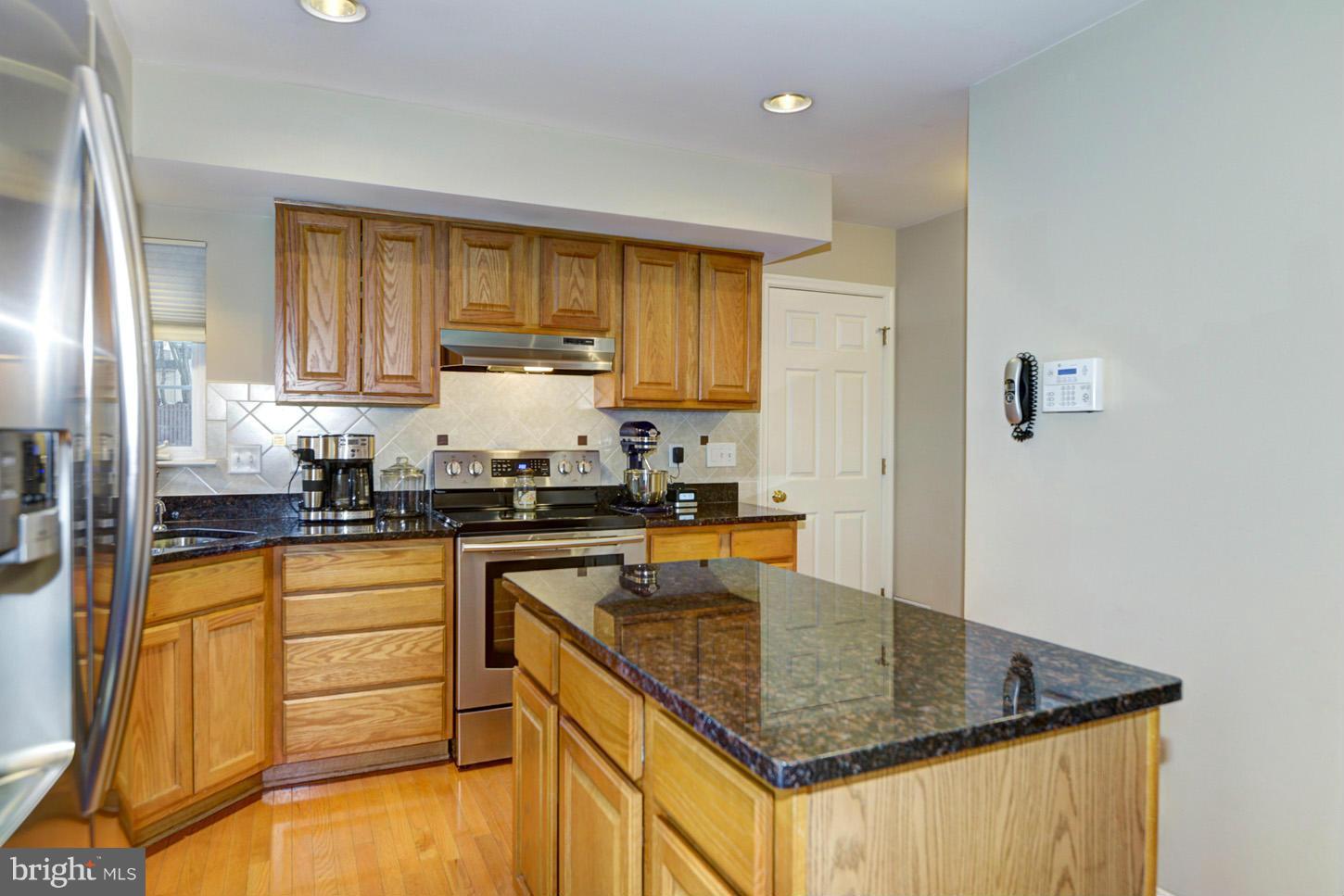 9522 Rommel Drive Columbia, MD 21046 - Photo 4 of 30 a kitchen with stainless steel appliances granite countertop a sink a stove and cabinets