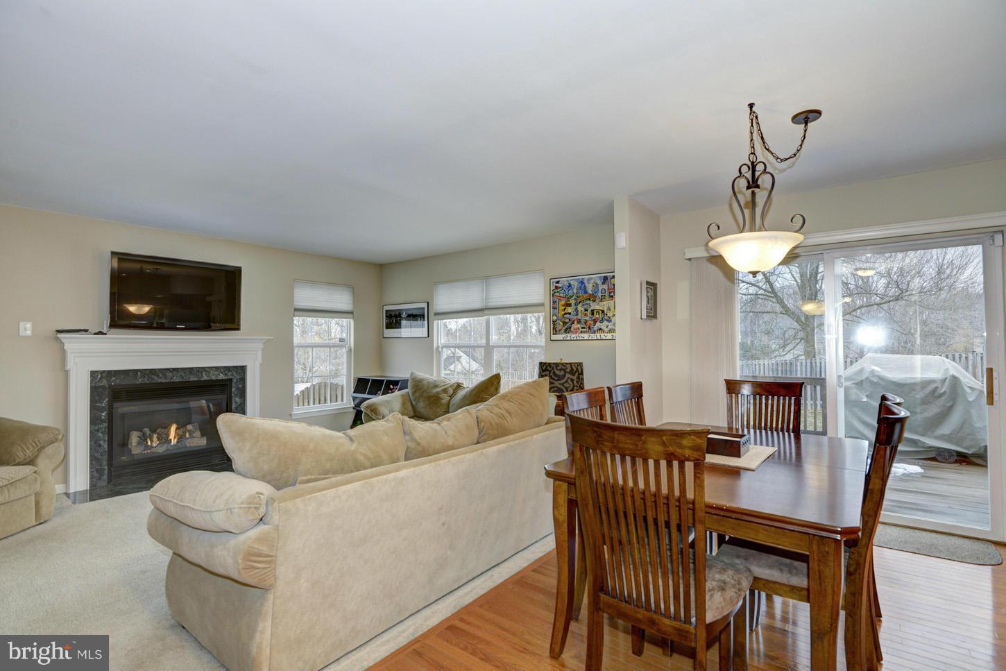 9522 Rommel Drive Columbia, MD 21046 - Photo 6 of 30 a living room with furniture a fireplace and a flat screen tv