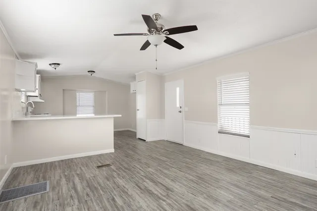 a view of an empty room with window and wooden floor