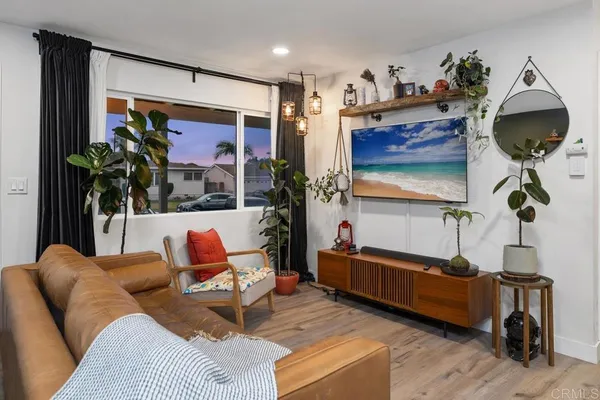 a living room with furniture a chandelier and a wooden floor