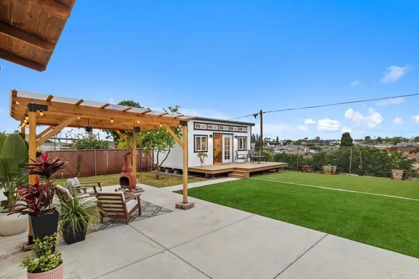 a view of a patio with table and chairs a barbeque and wooden fence
