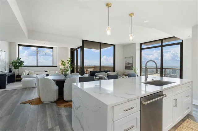 a living room with furniture a large window and dining table