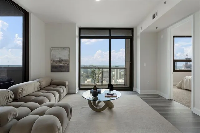 a living room with furniture and a dining table with kitchen view