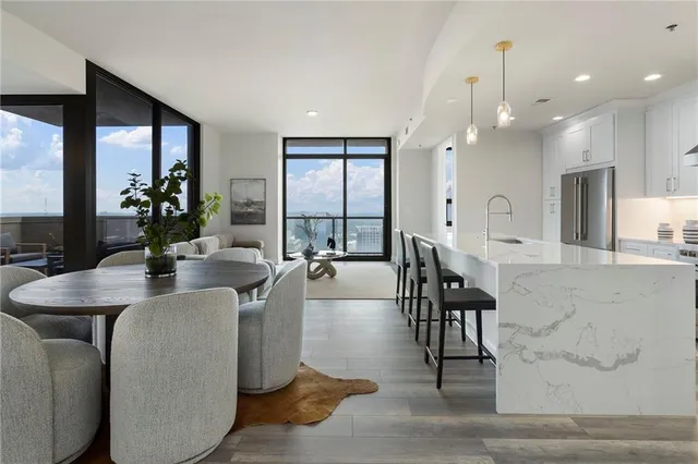 a large living room with stainless steel appliances kitchen island granite countertop furniture and a large window